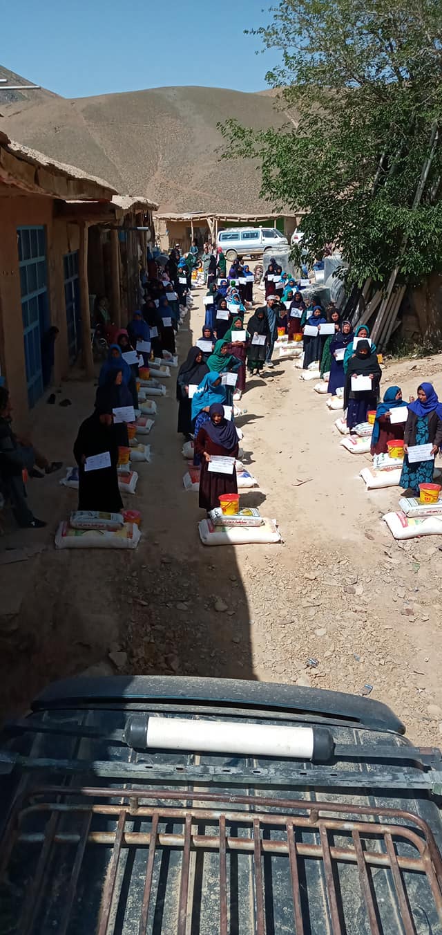 A vertical photograph of bags of food supplies arranged along a courtyard